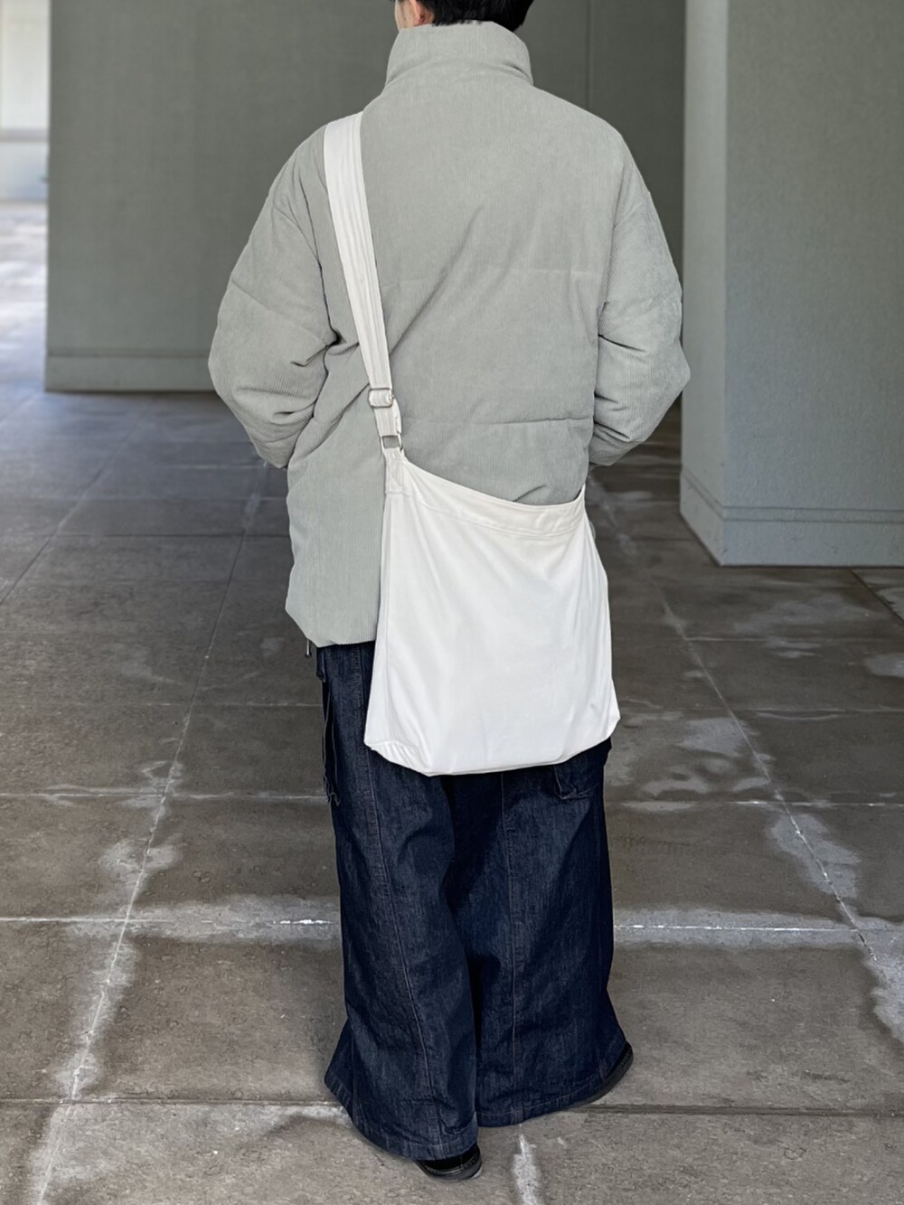 ブルー系のデニムパンツ、グリーン系のその他アウター、ベージュ系のショルダーバッグを着用したメンズの冬コーディネートの5枚目の写真