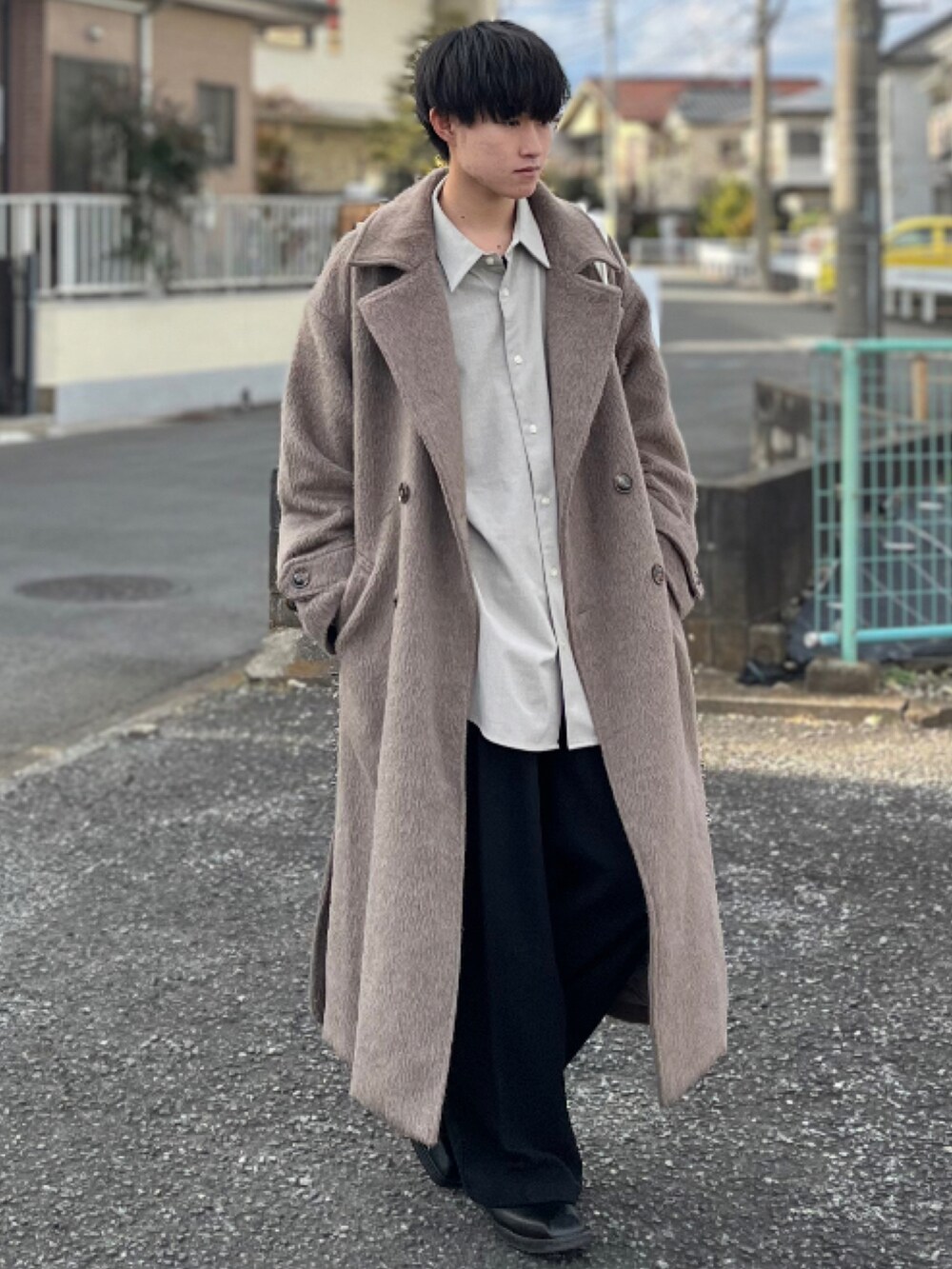 ブラック系のスラックス、ブラック系のブーツ、ブラウン系のチェスターコートを着用したメンズの冬コーディネートの5枚目の写真