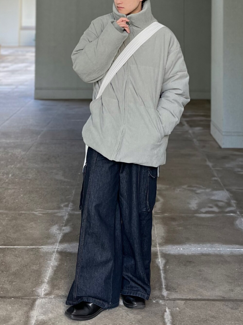 ブルー系のデニムパンツ、グリーン系のその他アウター、ベージュ系のショルダーバッグを着用したメンズの冬コーディネートの2枚目の写真