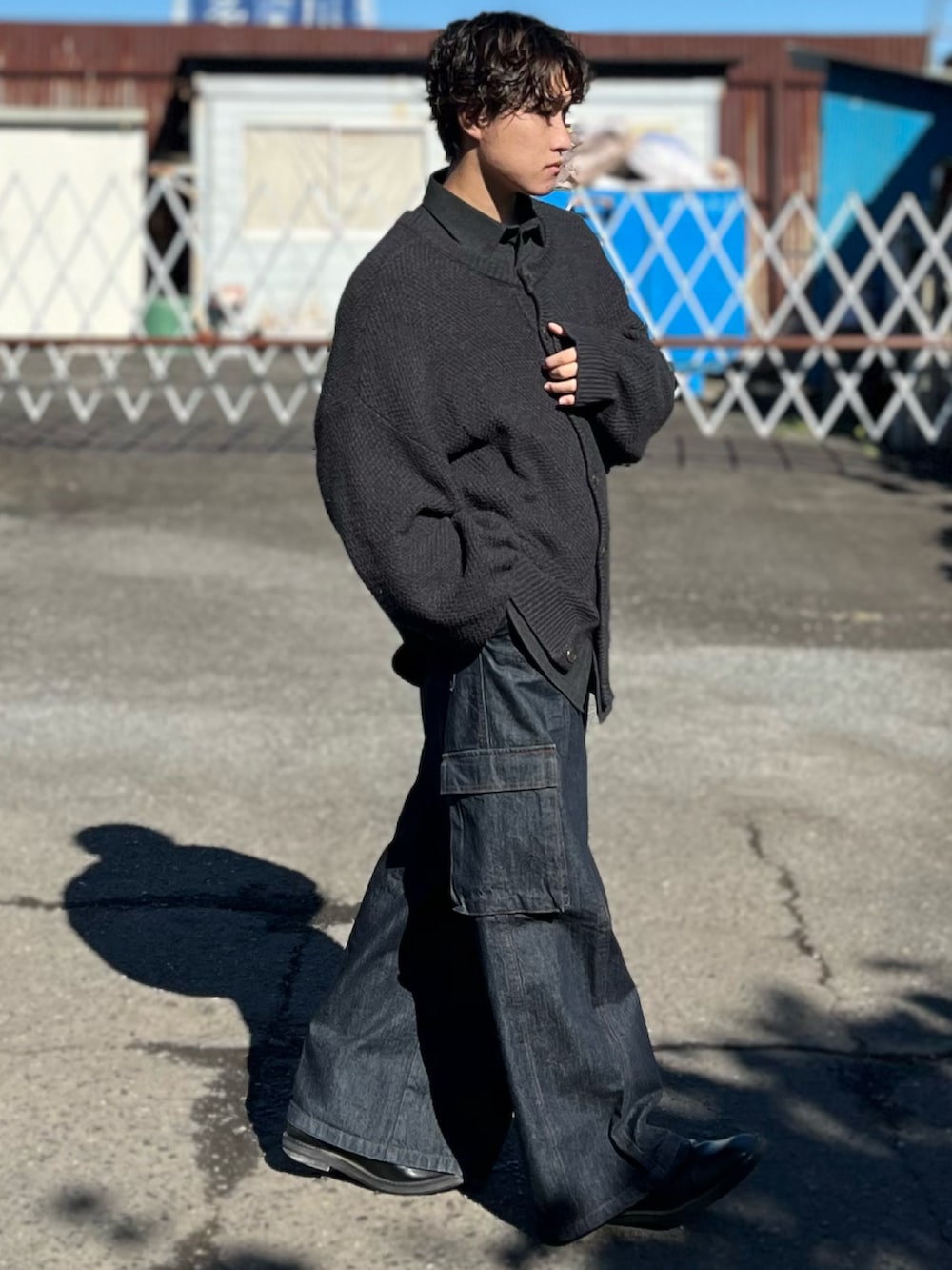 ブルー系のデニムパンツ、ブラック系のブーツ、グレー系のカーディガン/ボレロを着用したメンズの冬コーディネートの3枚目の写真