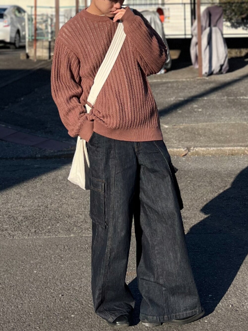 ブラウン系のニット/セーター、ブルー系のデニムパンツ、ブラック系のブーツを着用したメンズの冬コーディネートの4枚目の写真