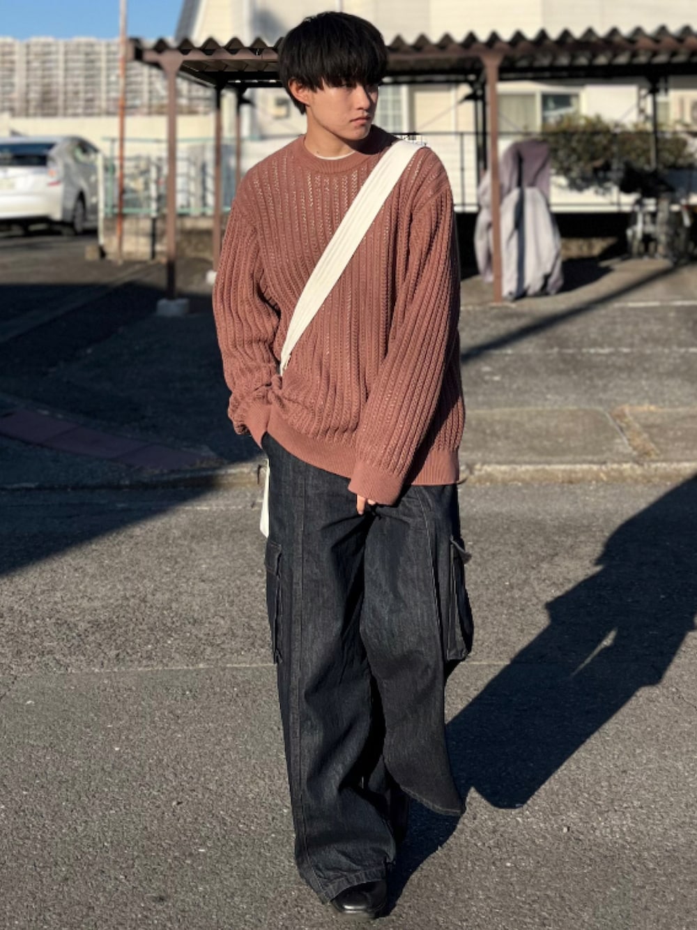 ブラウン系のニット/セーター、ブルー系のデニムパンツ、ブラック系のブーツを着用したメンズの冬コーディネートの2枚目の写真