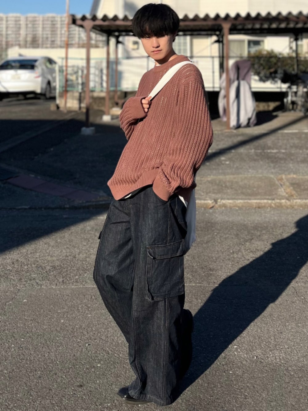 ブラウン系のニット/セーター、ブルー系のデニムパンツ、ブラック系のブーツを着用したメンズの冬コーディネートの3枚目の写真