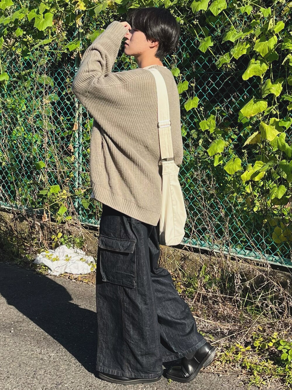 ブルー系のデニムパンツ、ベージュ系のカーディガン/ボレロ、グリーン系のTシャツ/カットソーを着用したメンズの秋コーディネートの5枚目の写真