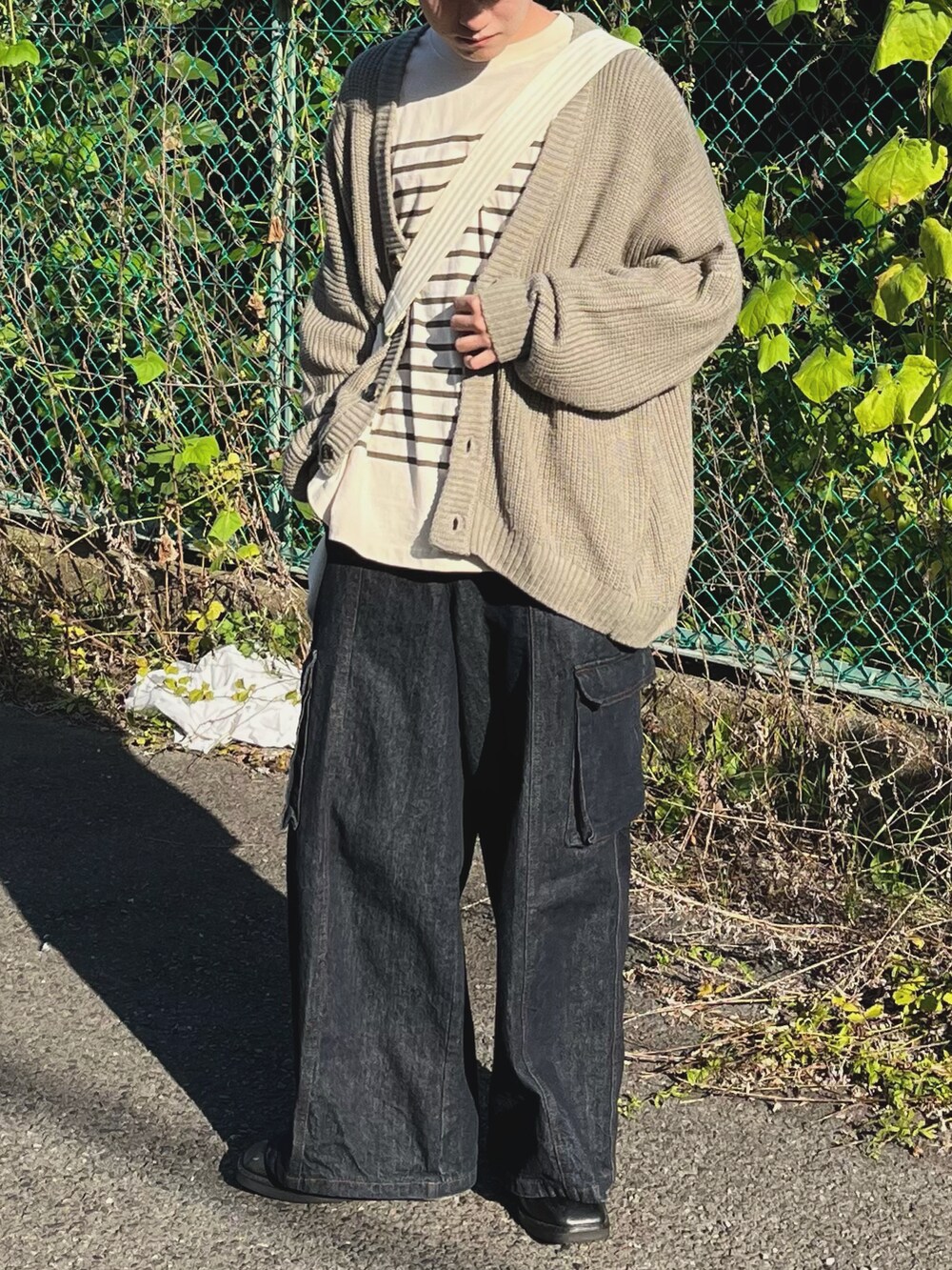 ブルー系のデニムパンツ、ベージュ系のカーディガン/ボレロ、グリーン系のTシャツ/カットソーを着用したメンズの秋コーディネートの2枚目の写真