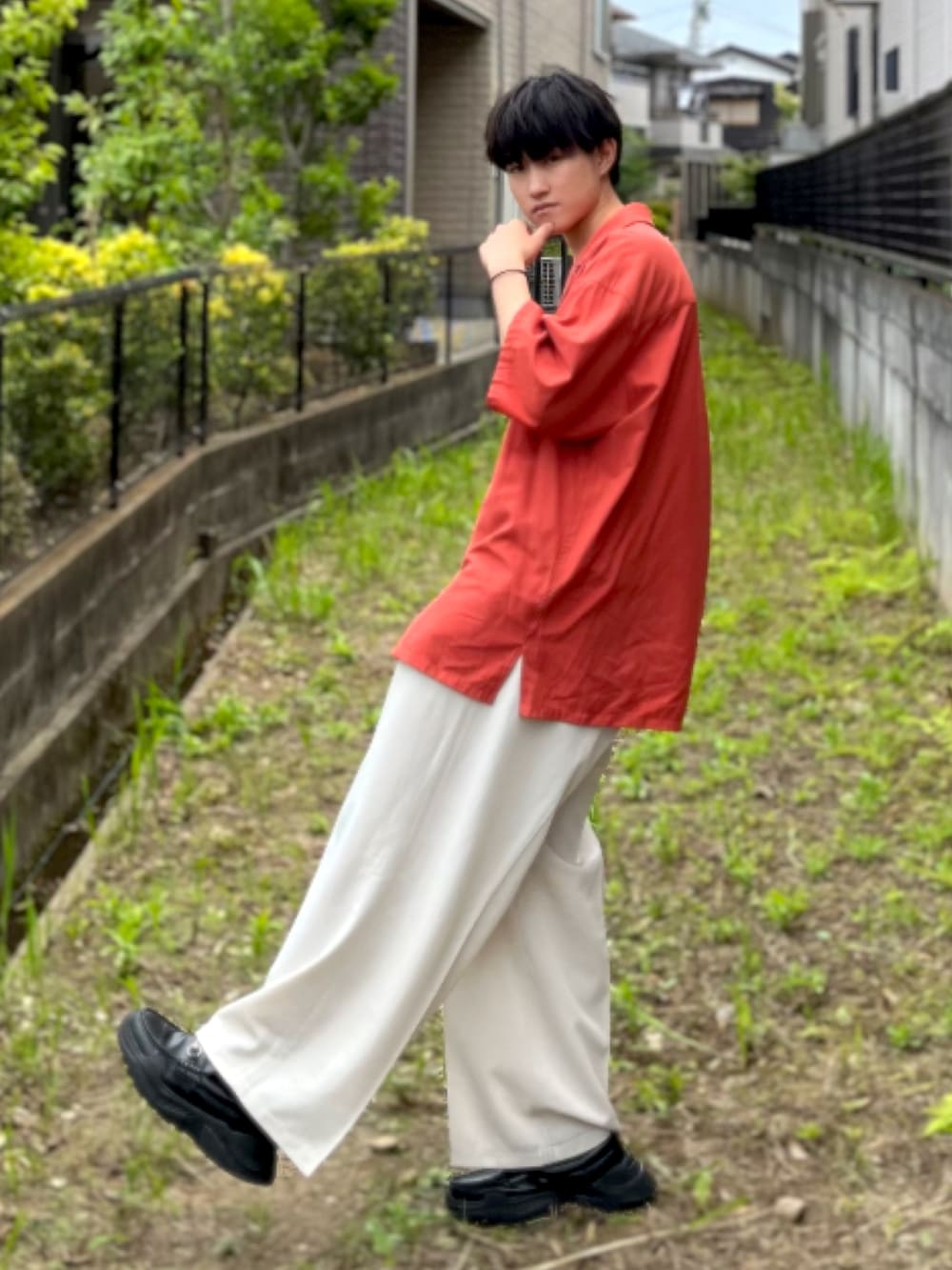 レッド系のシャツ/ブラウス、ホワイト系のスラックス、ブラック系のスニーカーを着用したメンズの夏コーディネートの3枚目の写真