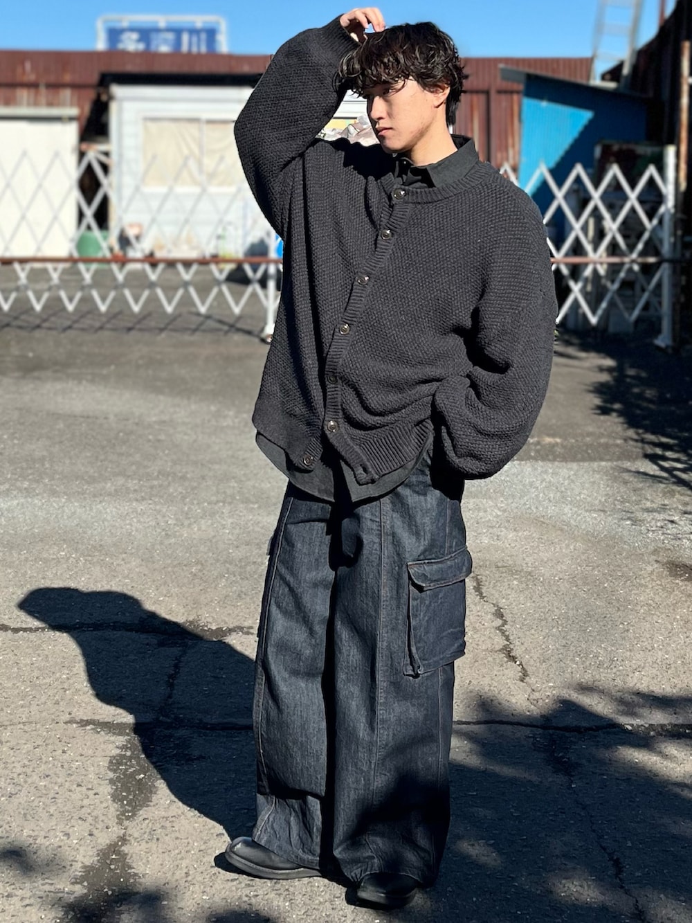 ブルー系のデニムパンツ、ブラック系のブーツ、グレー系のカーディガン/ボレロを着用したメンズの冬コーディネートの4枚目の写真