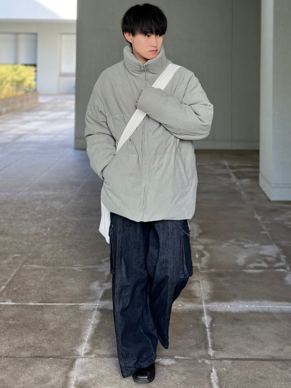 ブルー系のデニムパンツ、グリーン系のその他アウター、ベージュ系のショルダーバッグを着用したメンズの冬コーディネートの3枚目の写真