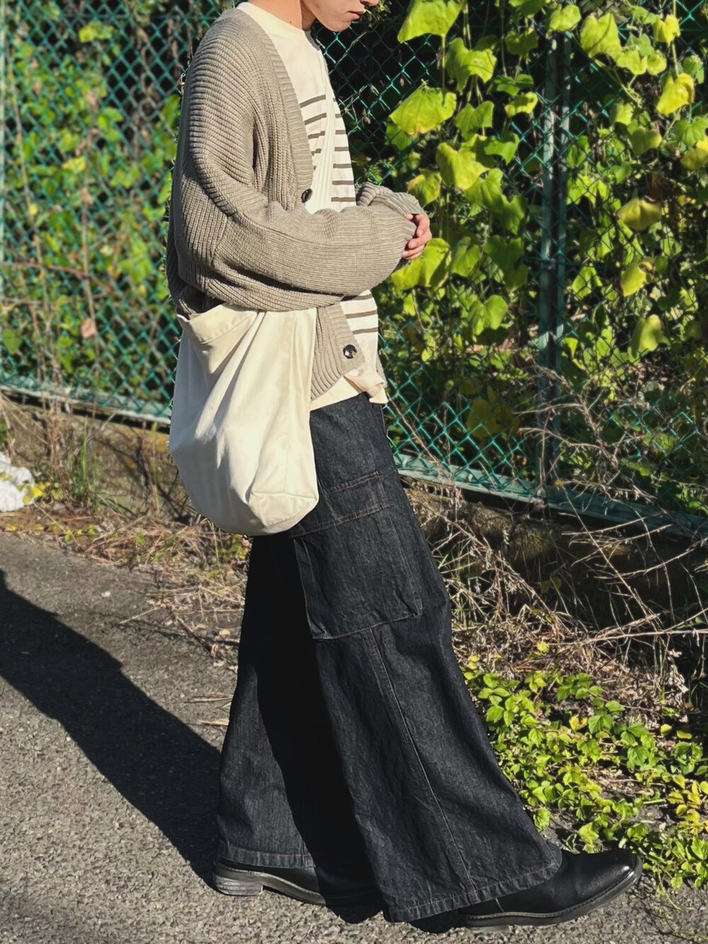 ブルー系のデニムパンツ、ベージュ系のカーディガン/ボレロ、グリーン系のTシャツ/カットソーを着用したメンズの秋コーディネートの4枚目の写真