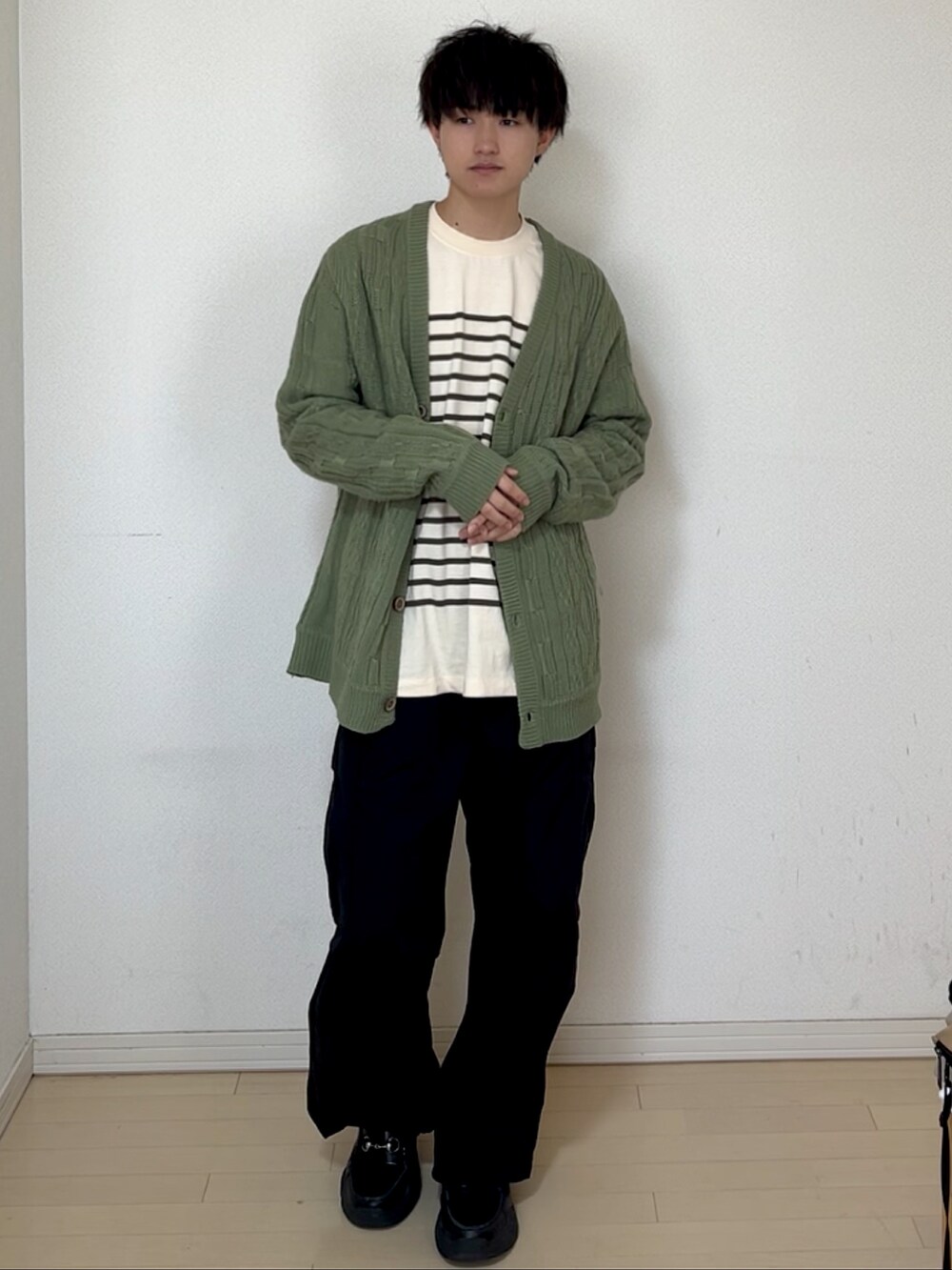 ブラック系のカーゴパンツ、ブラック系のスニーカー、グリーン系のTシャツ/カットソーを着用したメンズの春コーディネートの3枚目の写真