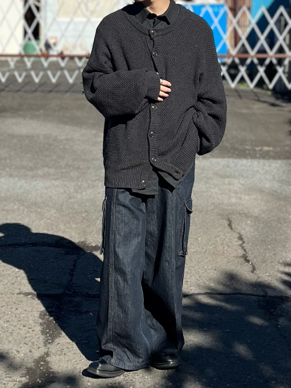 ブルー系のデニムパンツ、ブラック系のブーツ、グレー系のカーディガン/ボレロを着用したメンズの冬コーディネートの2枚目の写真