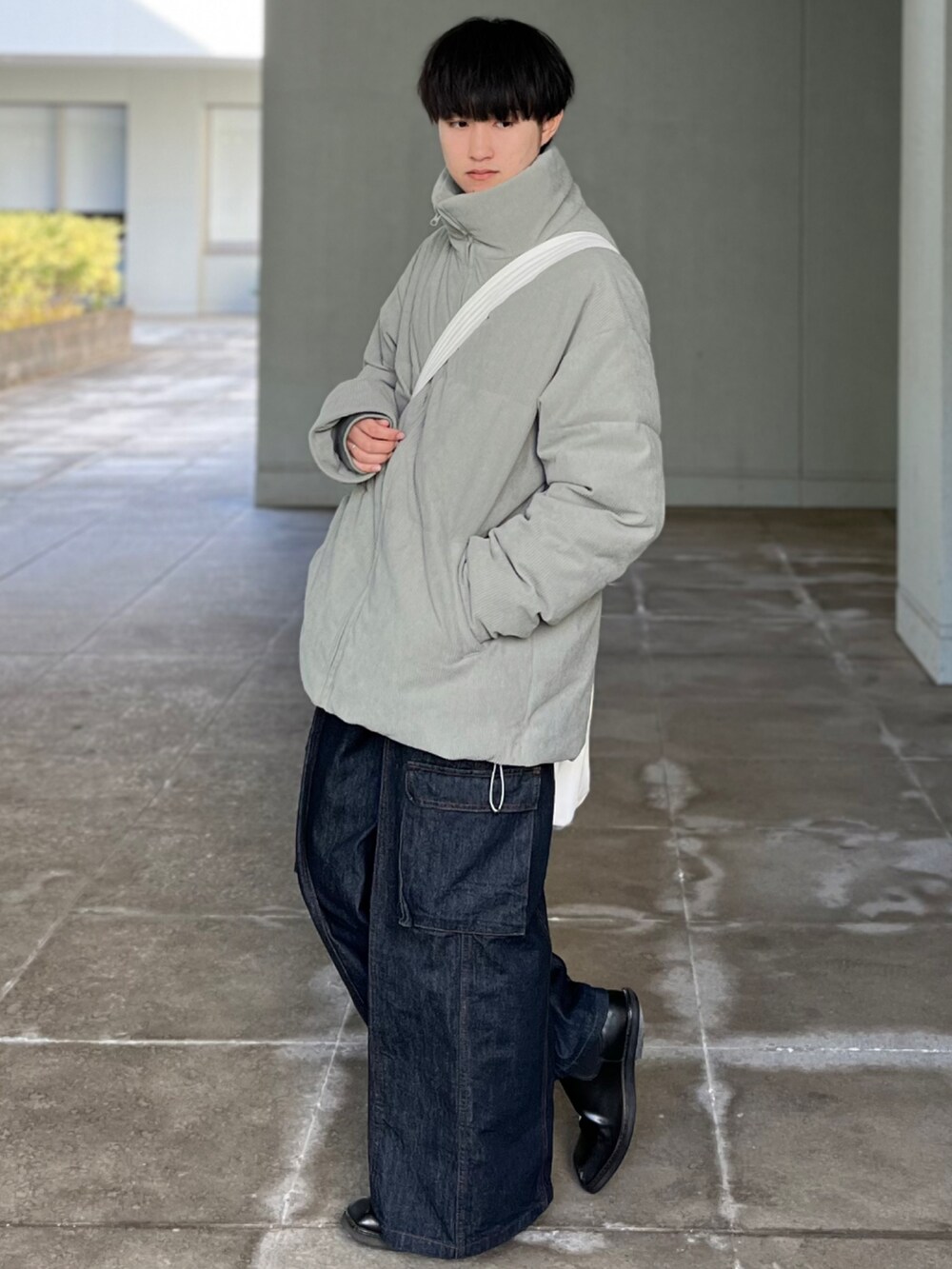 ブルー系のデニムパンツ、グリーン系のその他アウター、ベージュ系のショルダーバッグを着用したメンズの冬コーディネートの4枚目の写真