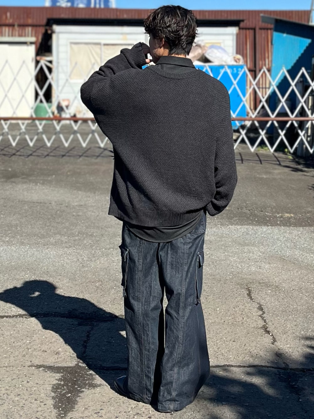 ブルー系のデニムパンツ、ブラック系のブーツ、グレー系のカーディガン/ボレロを着用したメンズの冬コーディネートの5枚目の写真