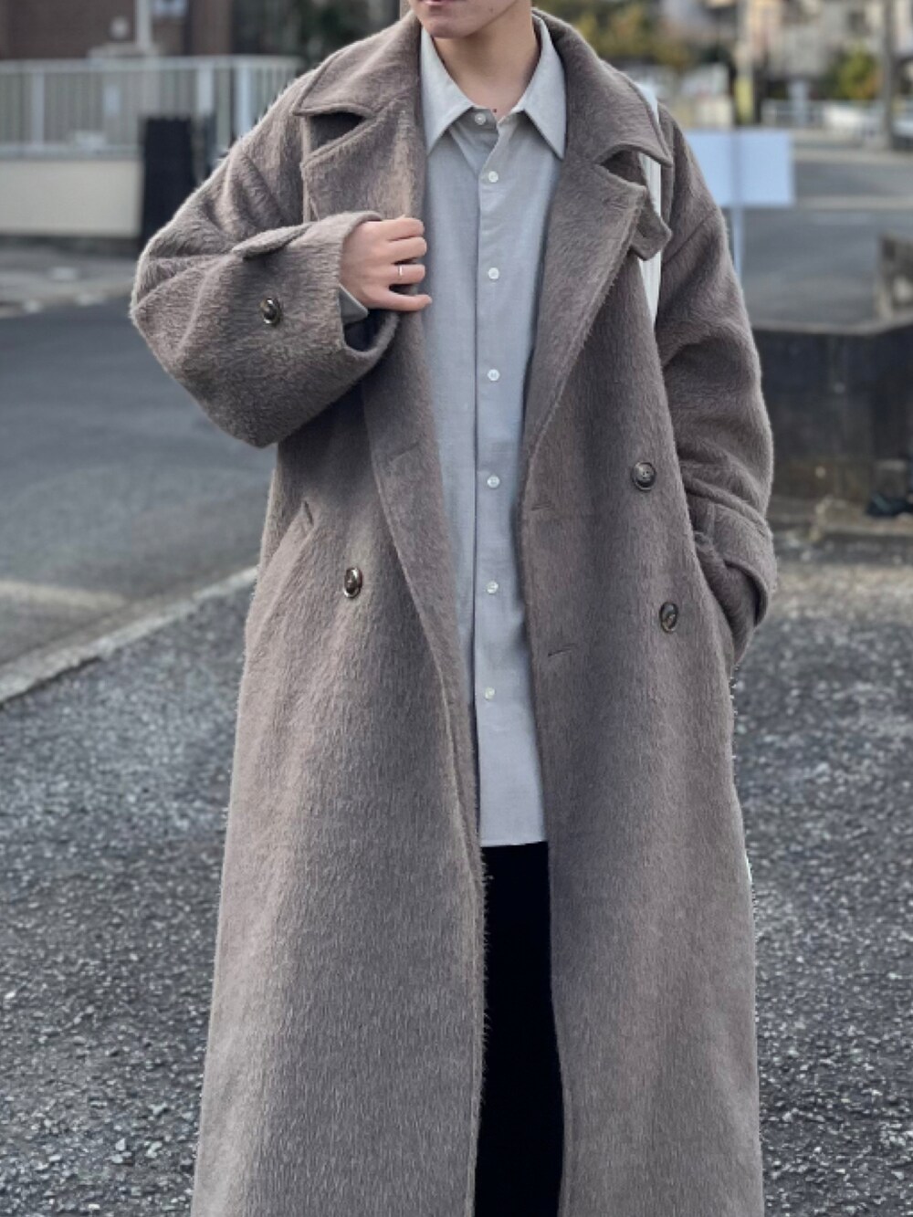 ブラック系のスラックス、ブラック系のブーツ、ブラウン系のチェスターコートを着用したメンズの冬コーディネートの2枚目の写真