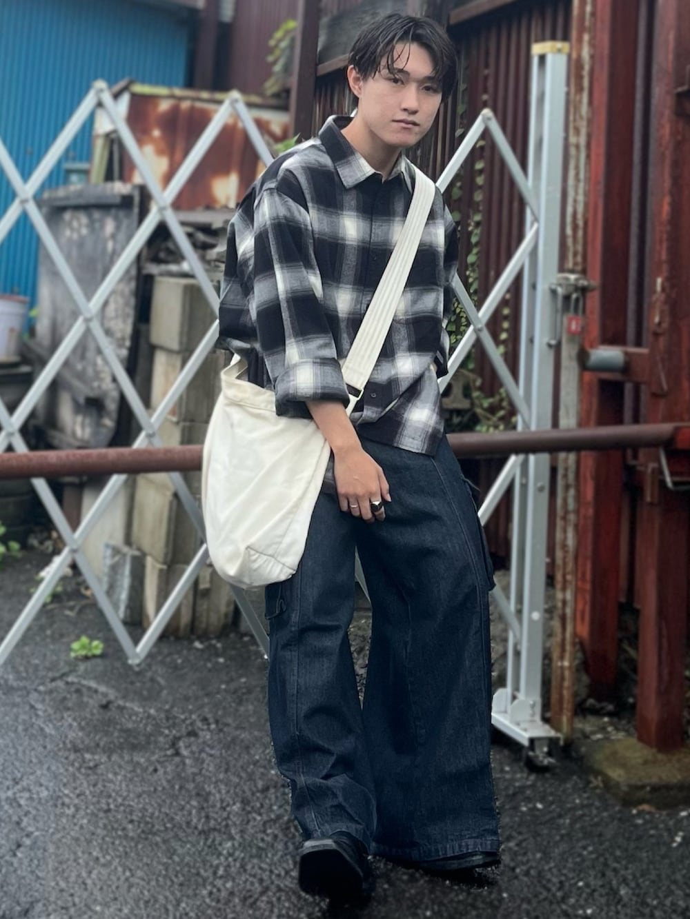 ブラック系のシャツ/ブラウス、ベージュ系のショルダーバッグ、ブルー系のデニムパンツを着用したメンズの秋コーディネートの3枚目の写真