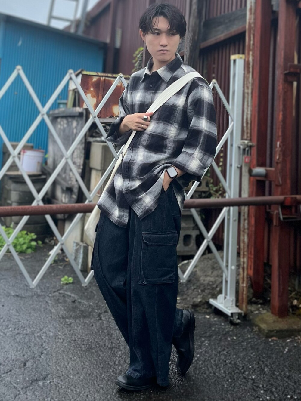 ブラック系のシャツ/ブラウス、ベージュ系のショルダーバッグ、ブルー系のデニムパンツを着用したメンズの秋コーディネートの4枚目の写真