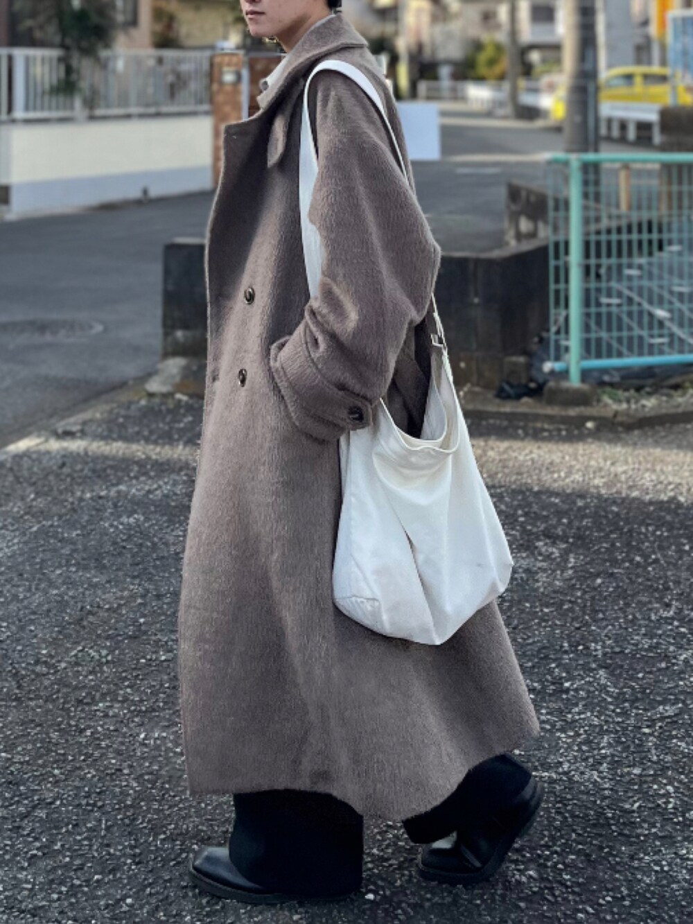 ブラック系のスラックス、ブラック系のブーツ、ブラウン系のチェスターコートを着用したメンズの冬コーディネートの4枚目の写真