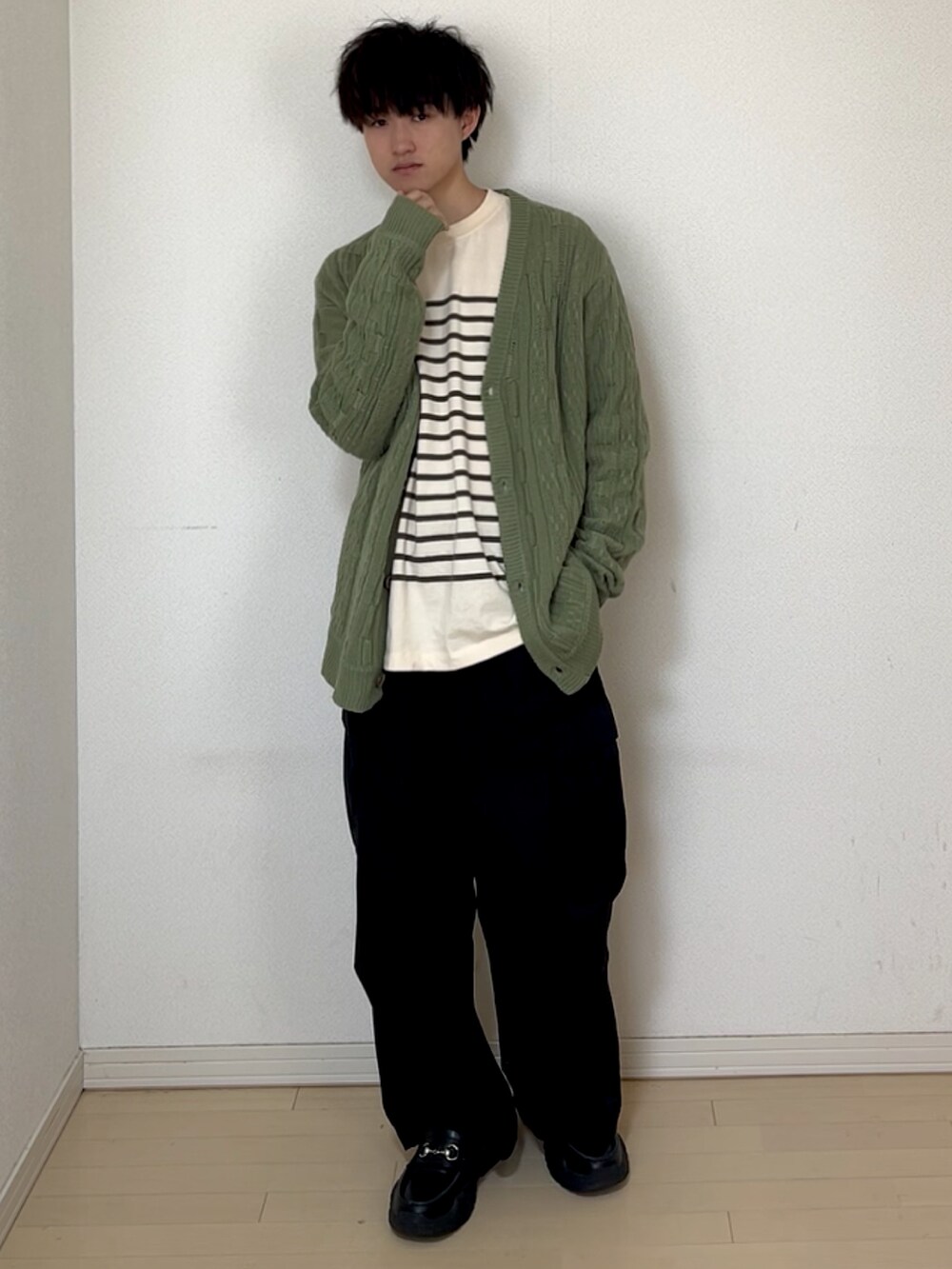 ブラック系のカーゴパンツ、ブラック系のスニーカー、グリーン系のTシャツ/カットソーを着用したメンズの春コーディネートの2枚目の写真