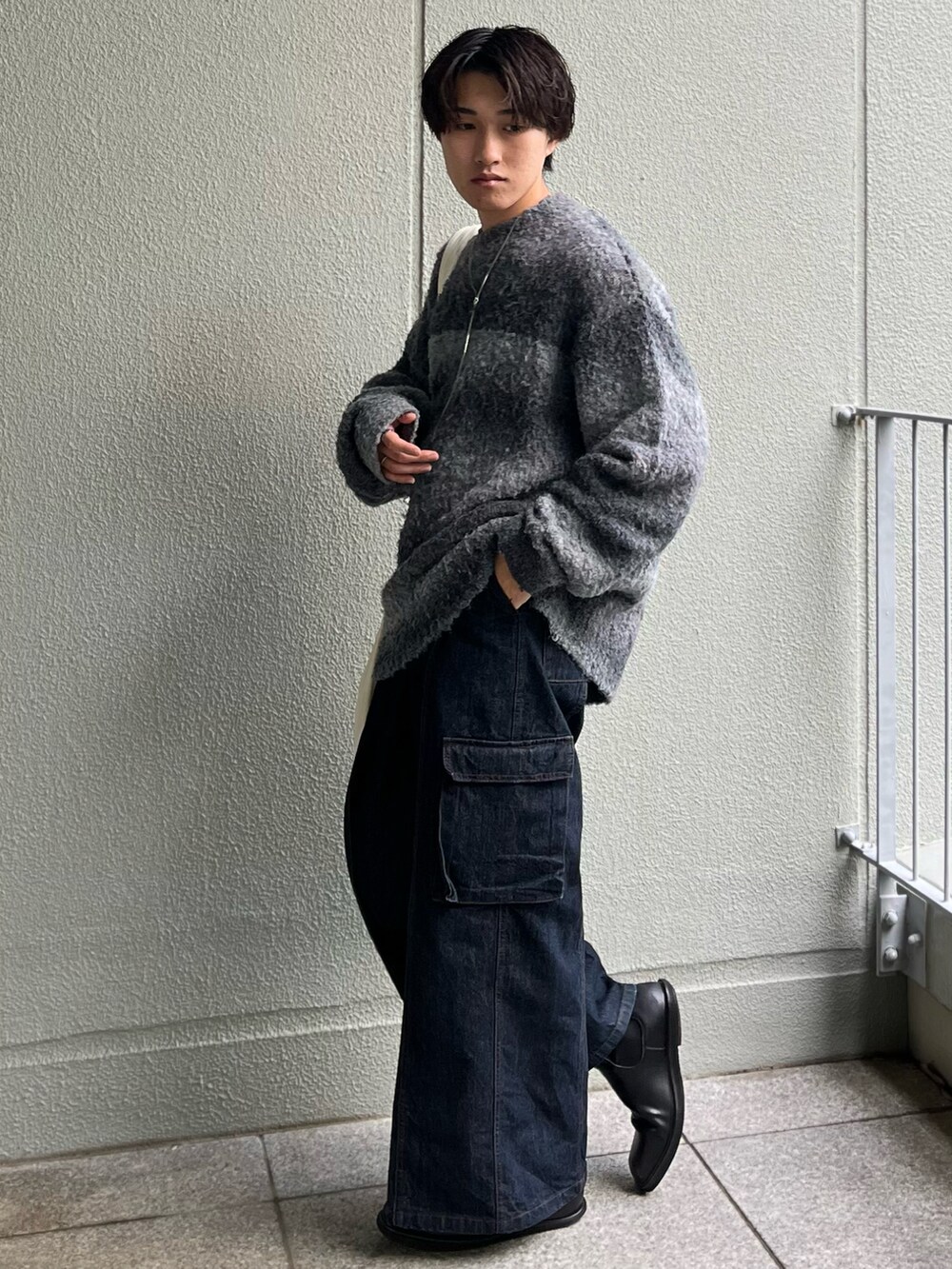 ベージュ系のショルダーバッグ、ブルー系のデニムパンツ、ブラック系のニット/セーターを着用したメンズの秋コーディネートの4枚目の写真