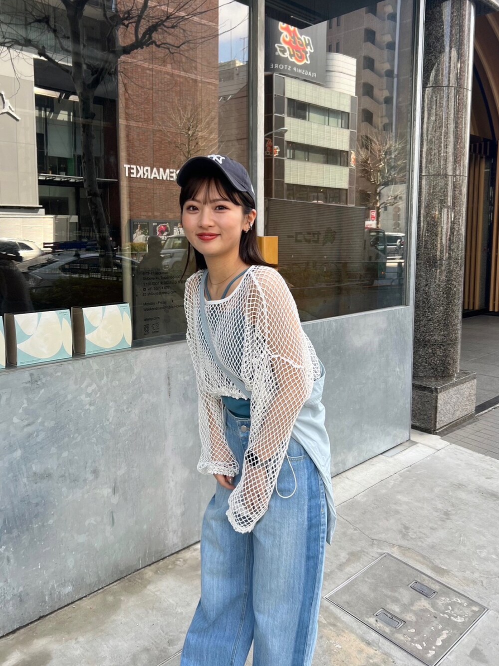 ブルー系のデニムパンツ、グリーン系のショルダーバッグ、ホワイト系のTシャツ/カットソーを着用したレディースの春コーディネートの3枚目の写真