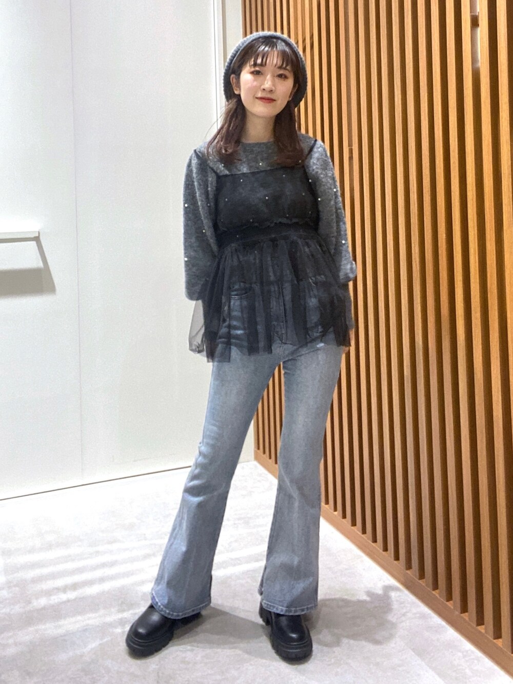 グレー系のニット/セーター、ブラック系のシャツ/ブラウス、ブルー系のデニムパンツを着用したレディースの冬コーディネートの5枚目の写真