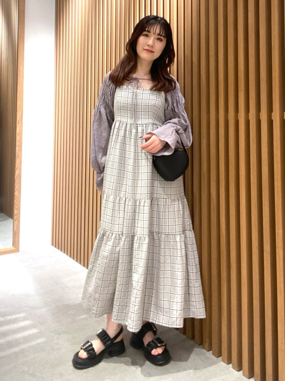 グレー系のカーディガン/ボレロ、ブラック系のサンダル、ホワイト系のキャミソールを着用したレディースの春コーディネートの3枚目の写真