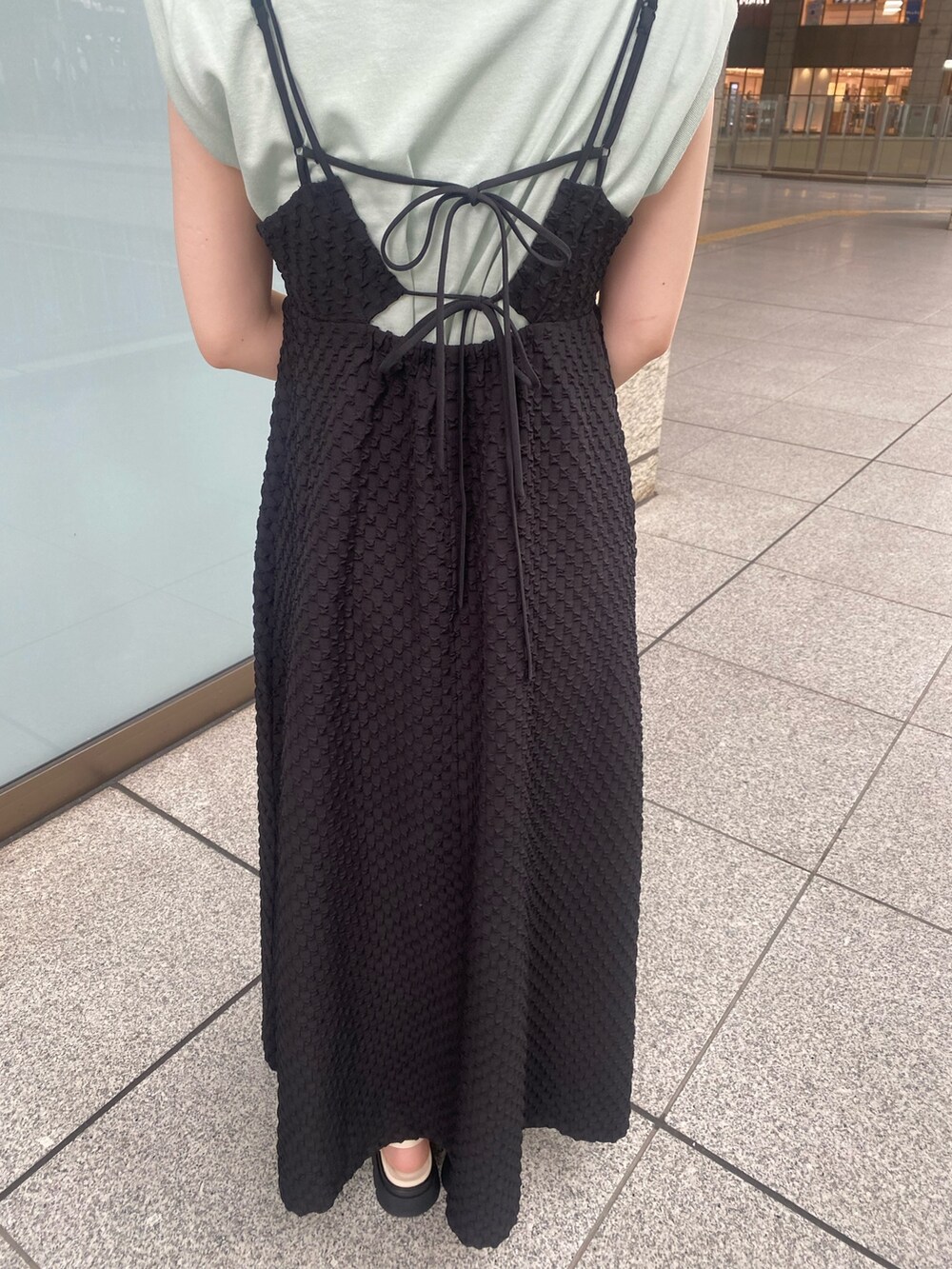 ホワイト系のサンダル、グリーン系のTシャツ/カットソー、ブラック系のワンピースを着用したレディースの夏コーディネートの5枚目の写真