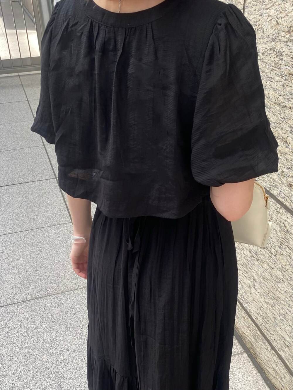 ブラック系のワンピース、ホワイト系のショルダーバッグ、レッド系のニット/セーターを着用したレディースの春コーディネートの4枚目の写真