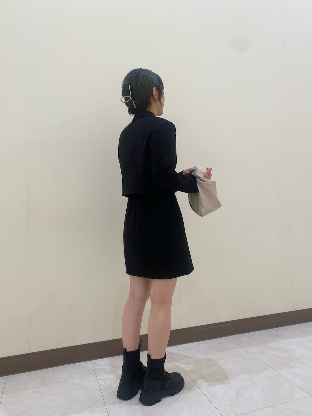 ブラック系のテーラードジャケット、ブラック系のワンピース、ベージュ系のTシャツ/カットソーを着用したレディースの秋コーディネートの4枚目の写真