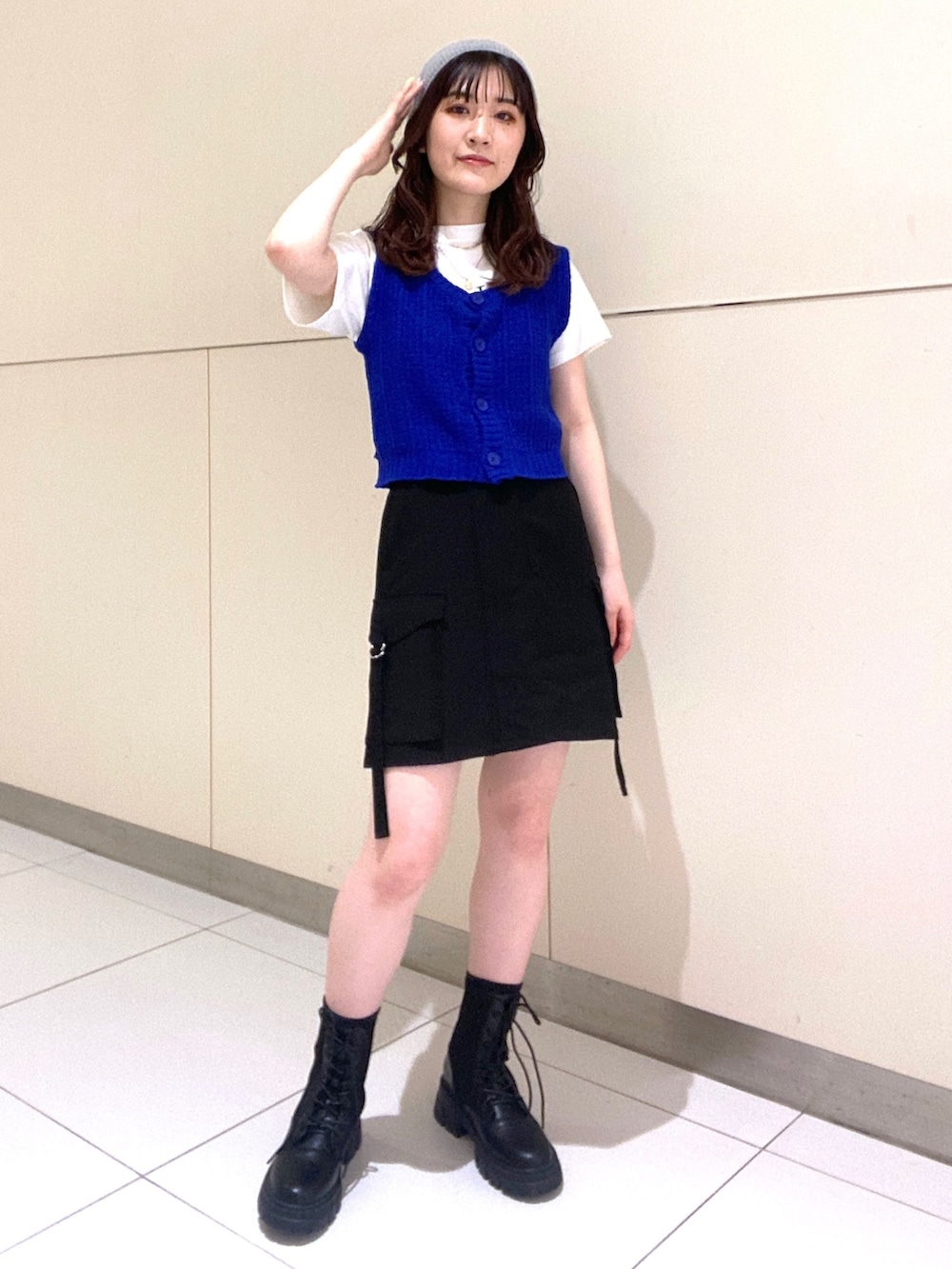 ブルー系のベスト、ホワイト系のTシャツ/カットソー、ブラック系のスカートを着用したレディースの春コーディネートの4枚目の写真