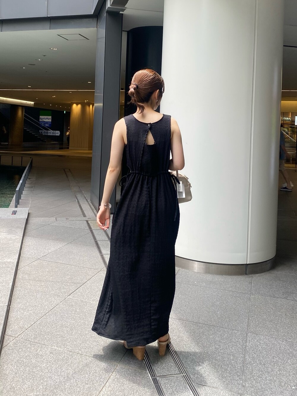 ブラック系のワンピース、グレー系のサンダル、ホワイト系のショルダーバッグを着用したレディースの夏コーディネートの3枚目の写真