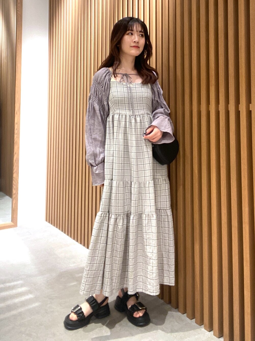 グレー系のカーディガン/ボレロ、ブラック系のサンダル、ホワイト系のキャミソールを着用したレディースの春コーディネートの2枚目の写真