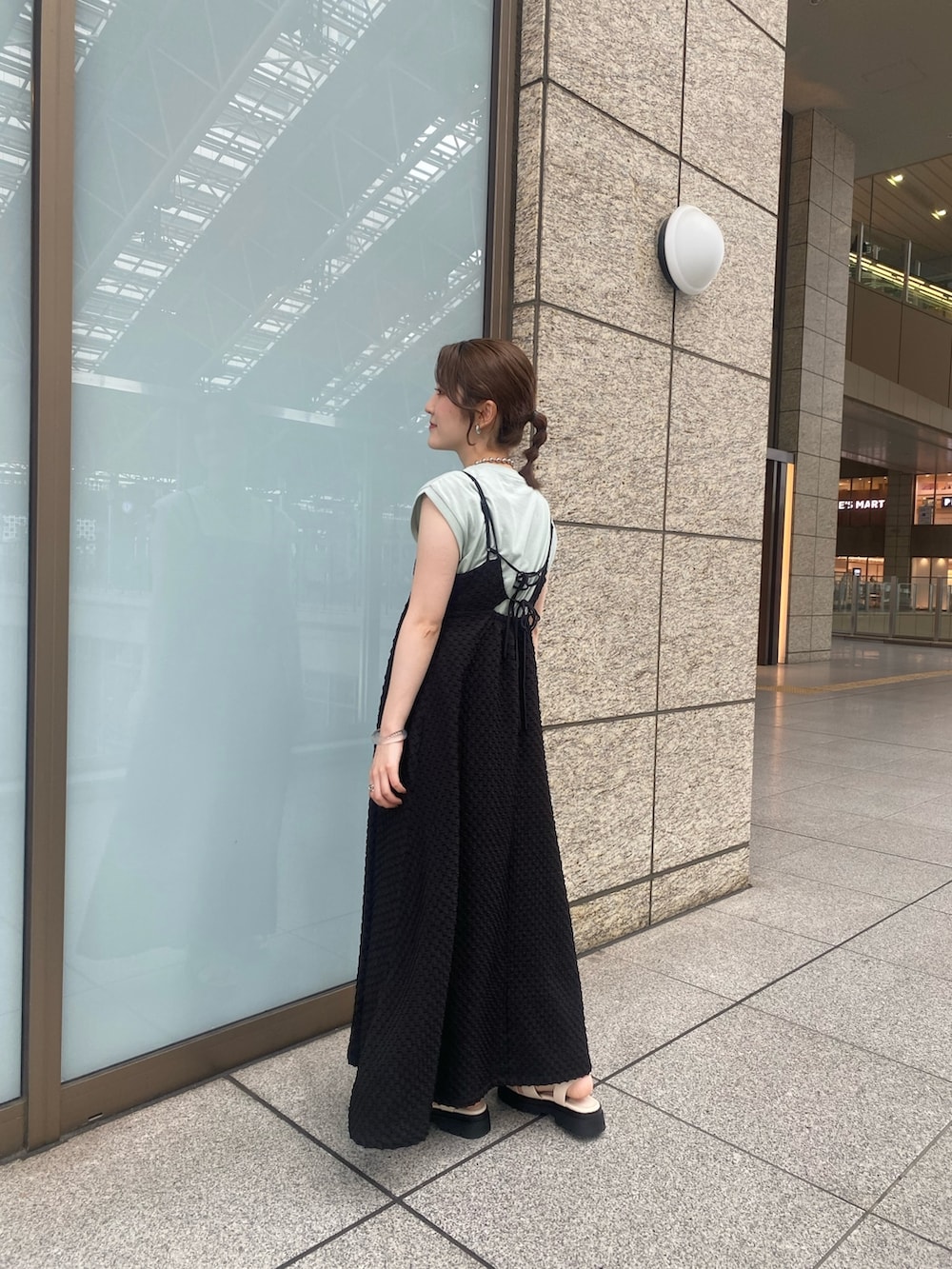 ホワイト系のサンダル、グリーン系のTシャツ/カットソー、ブラック系のワンピースを着用したレディースの夏コーディネートの2枚目の写真