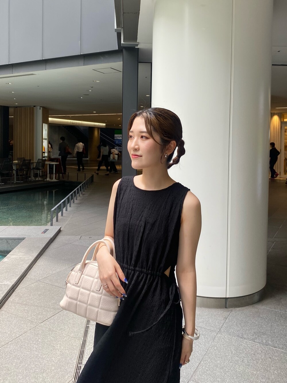 ブラック系のワンピース、グレー系のサンダル、ホワイト系のショルダーバッグを着用したレディースの夏コーディネートの5枚目の写真