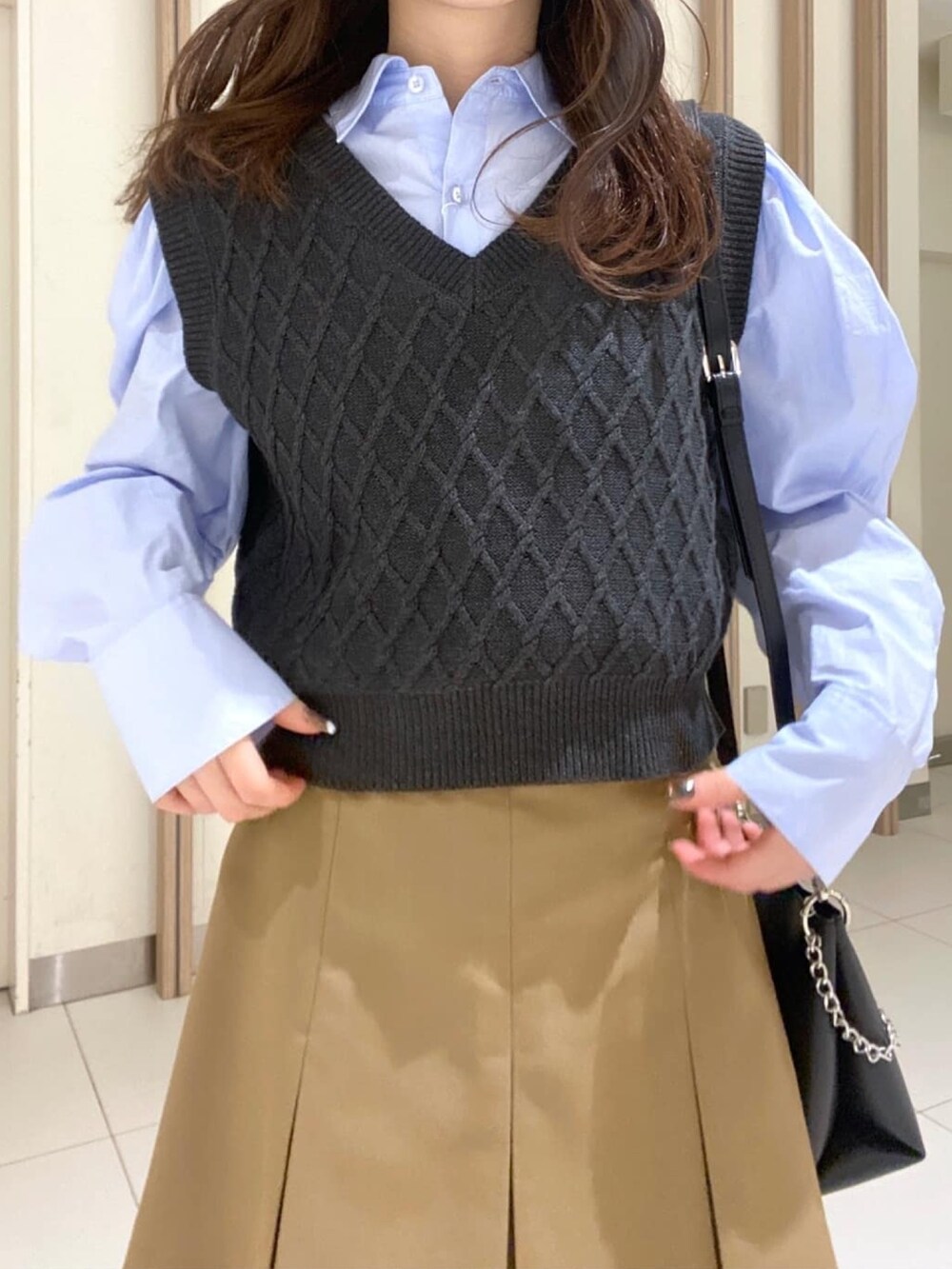 ブルー系のシャツ/ブラウス、ベージュ系のスカート、ブラック系のブーツを着用したレディースの冬コーディネートの4枚目の写真