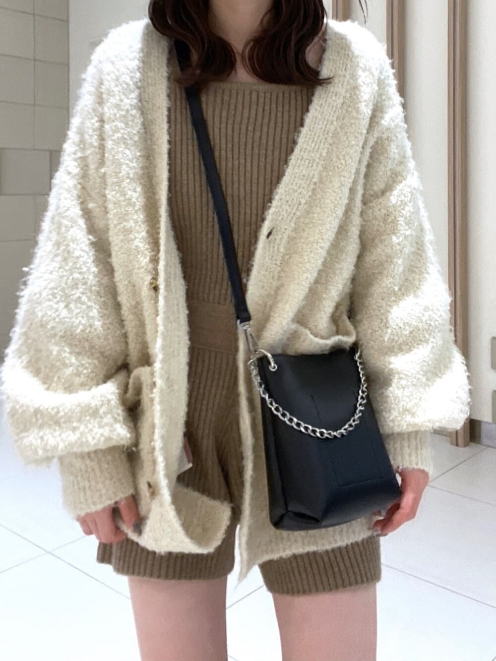 ホワイト系のカーディガン/ボレロ、ブラウン系のワンピース、ブラック系のブーツを着用したレディースの冬コーディネートの4枚目の写真