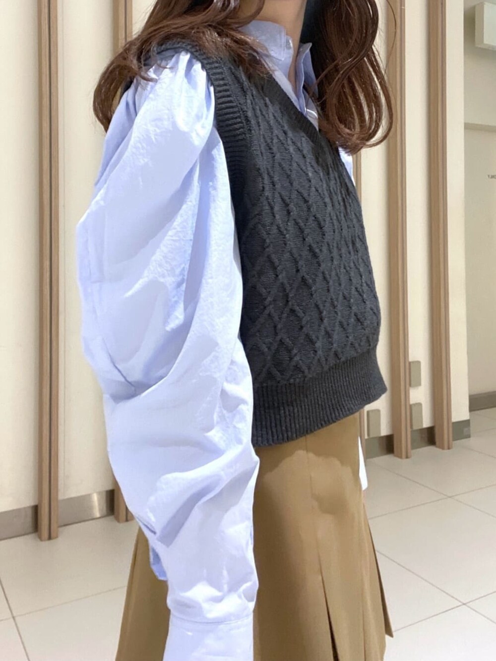 ブルー系のシャツ/ブラウス、ベージュ系のスカート、ブラック系のブーツを着用したレディースの冬コーディネートの5枚目の写真