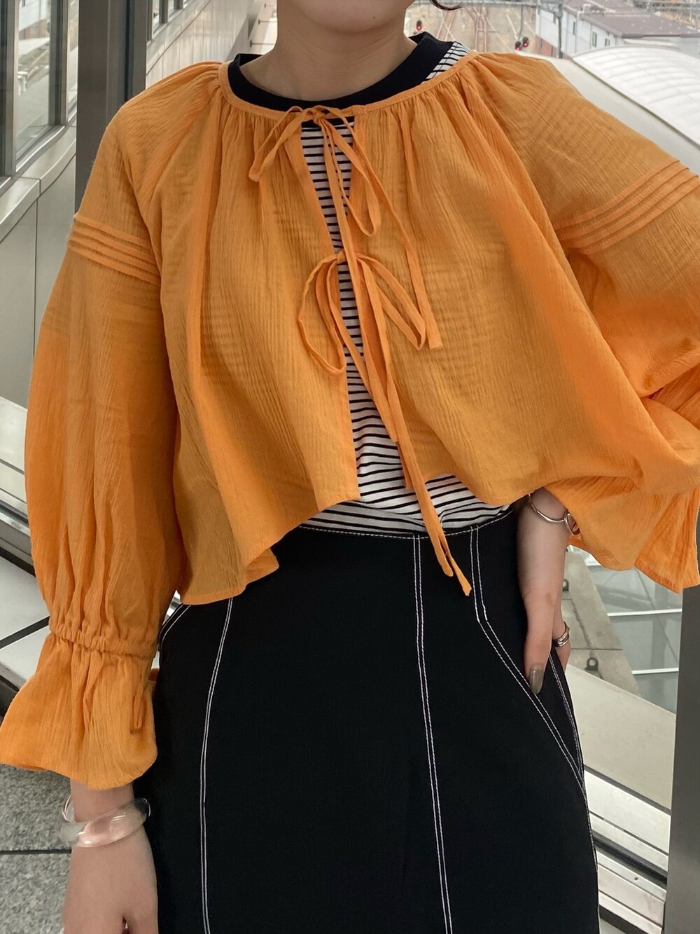 オレンジ系のシャツ/ブラウス、ブラック系のTシャツ/カットソー、ブラック系のスカートを着用したレディースの夏コーディネートの4枚目の写真