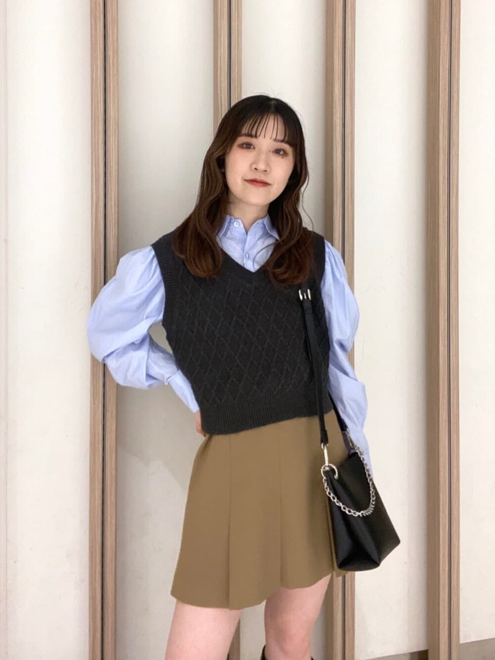 ブルー系のシャツ/ブラウス、ベージュ系のスカート、ブラック系のブーツを着用したレディースの冬コーディネートの7枚目の写真