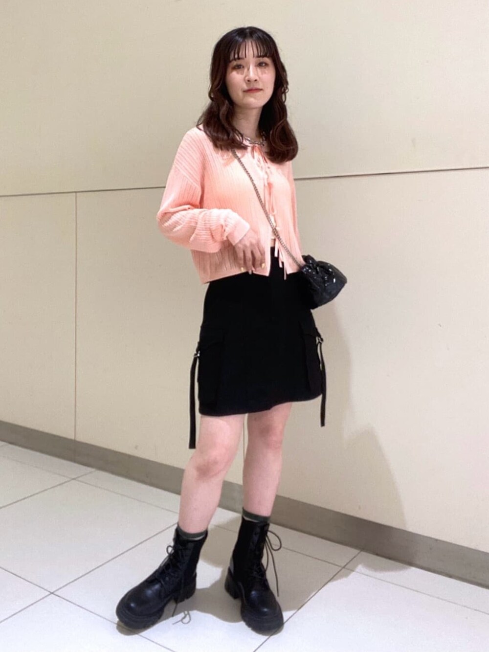 ホワイト系のキャミソール、ピンク系のカーディガン/ボレロ、ブラック系のスカートを着用したレディースの春コーディネートの3枚目の写真