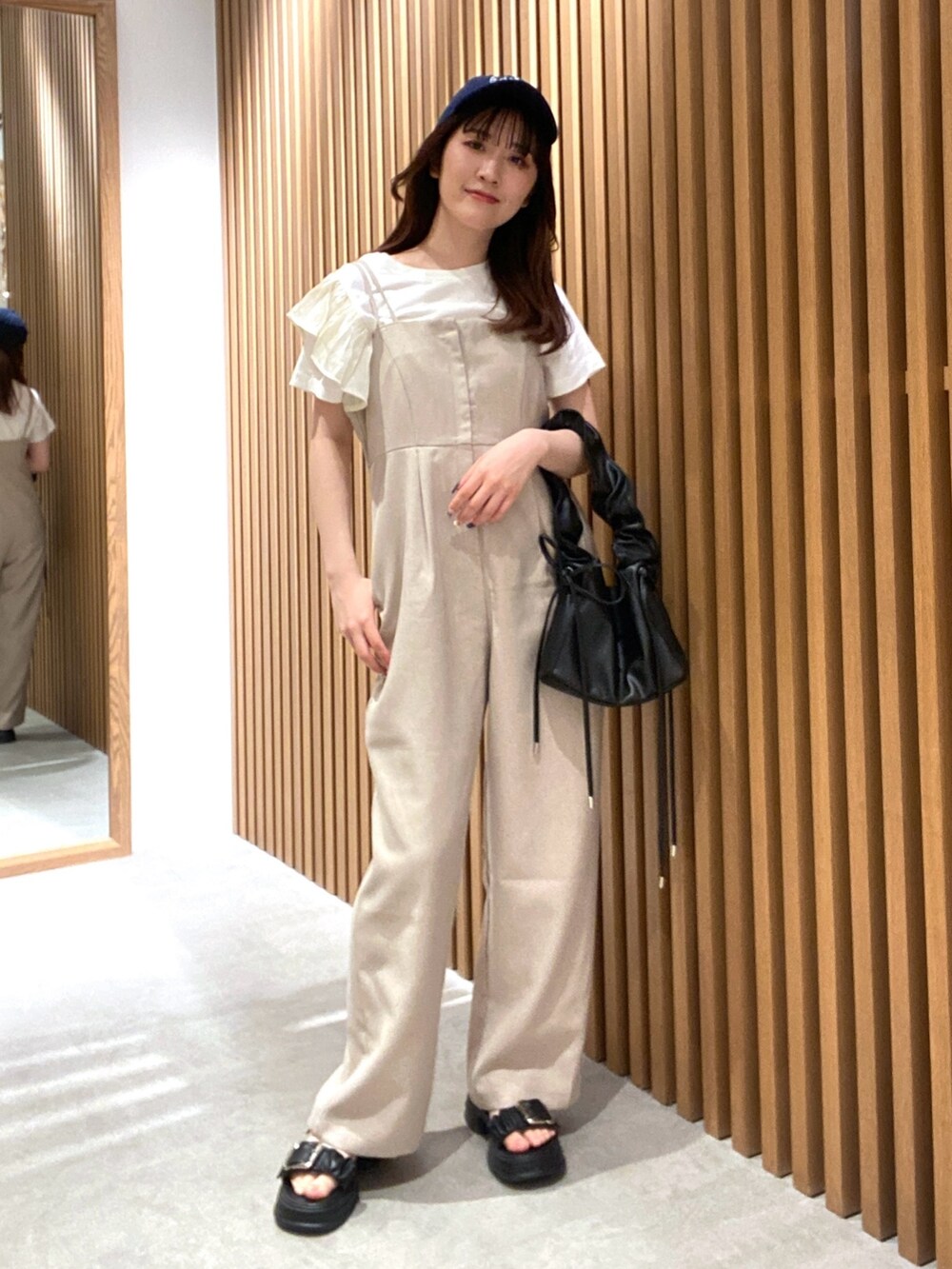 ベージュ系のつなぎ/オールインワン、ホワイト系のTシャツ/カットソー、ブラック系のサンダルを着用したレディースの夏コーディネートの2枚目の写真