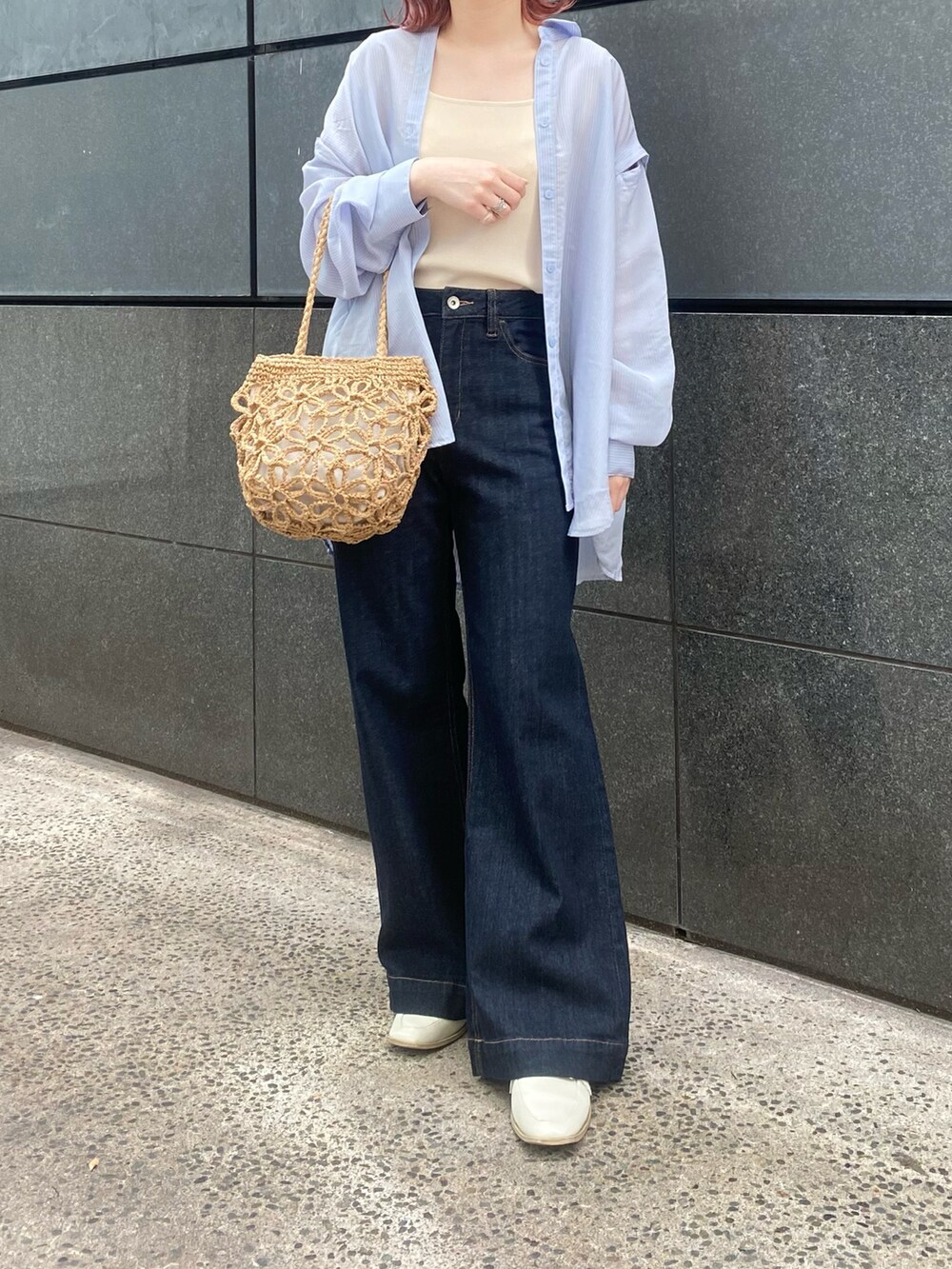 ブルー系のシャツ/ブラウス、ホワイト系のニット/セーター、ブルー系のデニムパンツを着用したレディースの春コーディネートの4枚目の写真