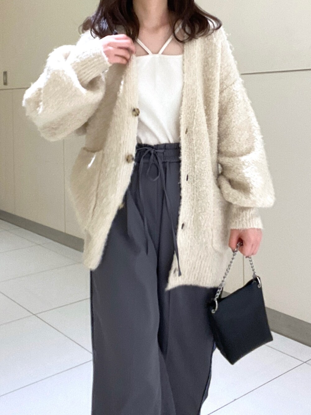 ホワイト系のカーディガン/ボレロ、グレー系のその他パンツ、ホワイト系のキャミソールを着用したレディースの秋コーディネートの4枚目の写真