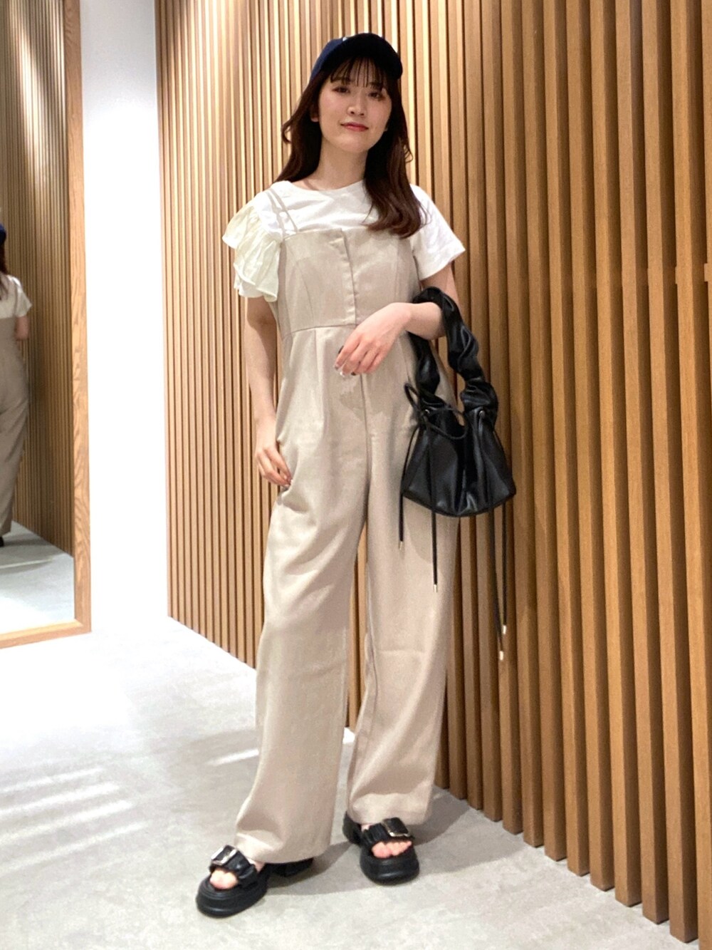ベージュ系のつなぎ/オールインワン、ホワイト系のTシャツ/カットソー、ブラック系のサンダルを着用したレディースの夏コーディネートの3枚目の写真