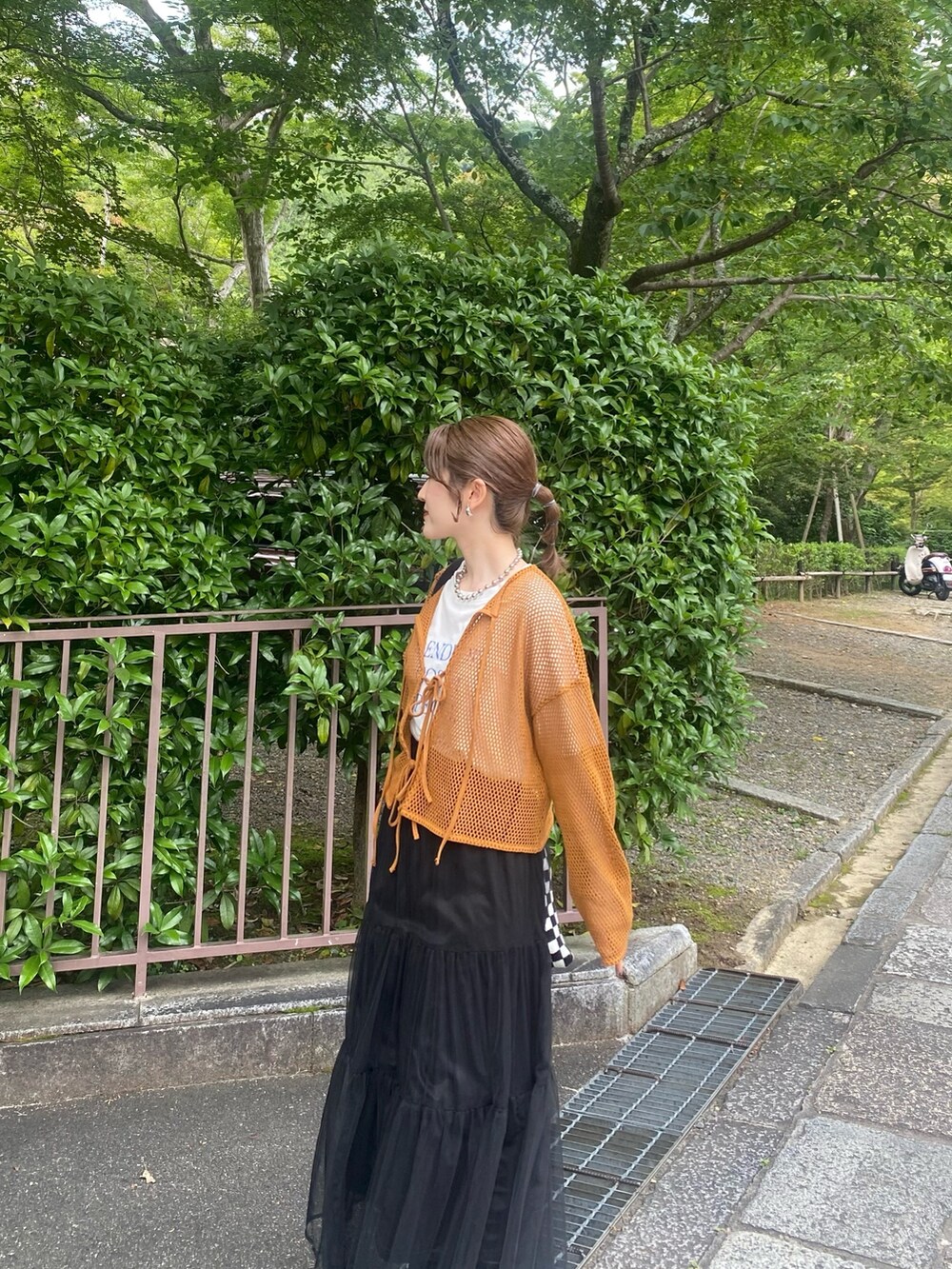 ブラウン系のTシャツ/カットソー、ブラック系のスカート、シルバー系のネックレスを着用したレディースの夏コーディネートの4枚目の写真