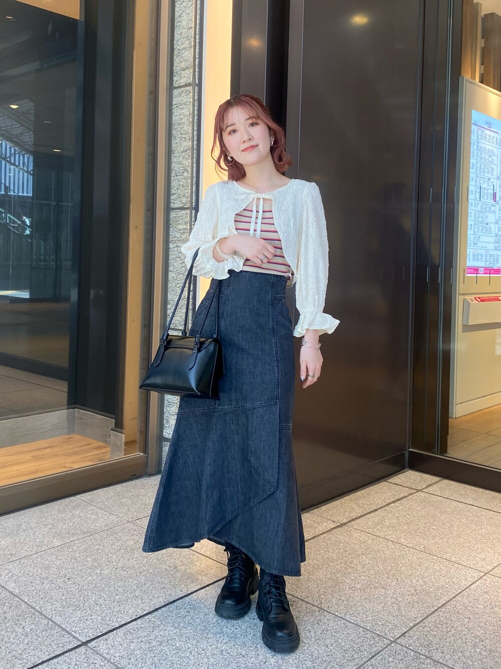 ホワイト系のシャツ/ブラウス、ベージュ系のタンクトップ、ブラック系のスカートを着用したレディースの春コーディネートの2枚目の写真