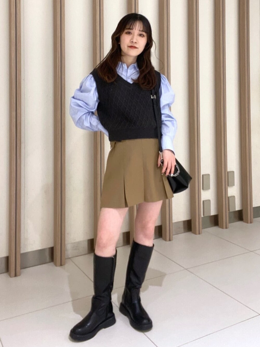 ブルー系のシャツ/ブラウス、ベージュ系のスカート、ブラック系のブーツを着用したレディースの冬コーディネートの3枚目の写真