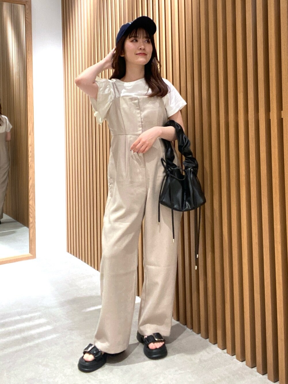 ベージュ系のつなぎ/オールインワン、ホワイト系のTシャツ/カットソー、ブラック系のサンダルを着用したレディースの夏コーディネートの4枚目の写真