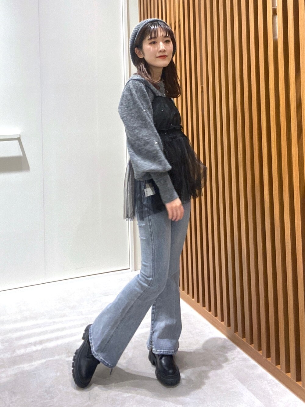 グレー系のニット/セーター、ブラック系のシャツ/ブラウス、ブルー系のデニムパンツを着用したレディースの冬コーディネートの3枚目の写真