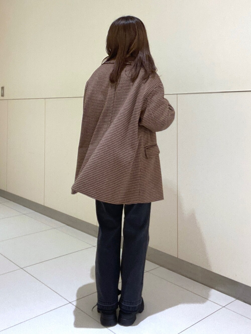 ベージュ系のピーコート、グレー系のニット/セーター、ブラック系のデニムパンツを着用したレディースの冬コーディネートの3枚目の写真